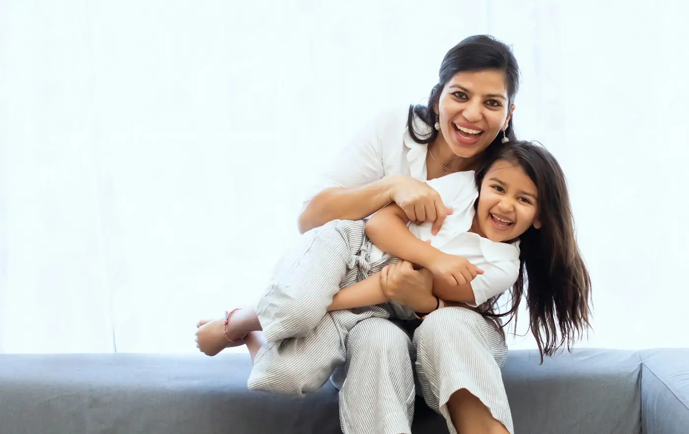 Mother and daughter smiling at home